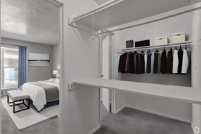 Dallas apartment for rent - a bedroom with a bed and a closet with a rack of clothes