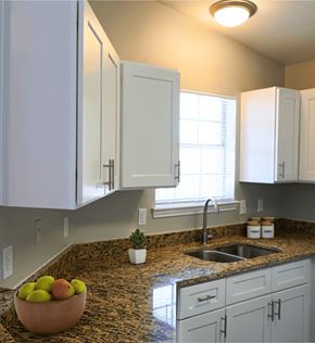 San Antonio apartment for rent - a kitchen with white cabinets and a granite counter top and a sink