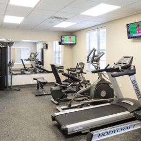 Kent apartment for rent - a room filled with lots of cardio equipment and a flat screen tv