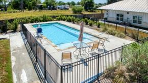 Cuero apartment for rent - A pool surrounded by a black fence with a sun lounger and table.