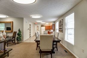 Shinnston apartment for rent - A living room with a couch, chairs, and a dining table.