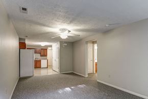 Shinnston apartment for rent - A spacious room with a refrigerator and a ceiling fan.