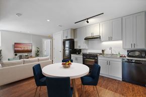 Washington apartment for rent - a kitchen and living room with white cabinets and a white table and chairs