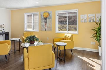 Bluefield apartment for rent - A living room with yellow chairs and a white table.