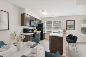 Queenstown townhouse for rent - a kitchen and dining room with a white table and chairs and a black