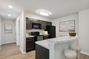 Queenstown apartment for rent - a kitchen with black appliances and a counter with two stools