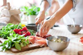 Shepherdstown apartment for rent - a woman cutting meat on a cutting board with vegetables on a table