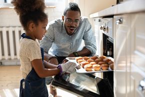Lincoln apartment for rent - a father and daughter putting a tray of donuts into an oven
