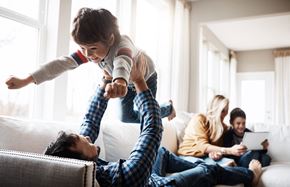 Lincoln apartment for rent - a young boy jumping on a man in the living room with his family