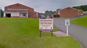 Terra Alta apartment for rent - A sign for Alpine Village Apartments is in front of a brick building.