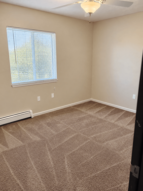 Traverse City apartment for rent - A room with a carpeted floor and a window with blinds.