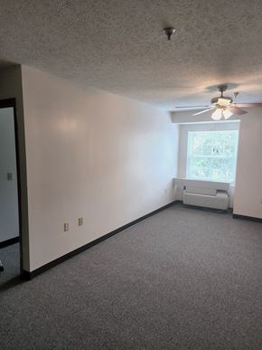 Lonaconing apartment for rent - an empty room with a ceiling fan and a window