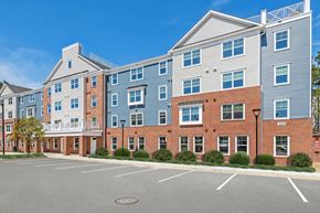 Queenstown apartment for rent - a brick apartment building with blue siding and a parking lot