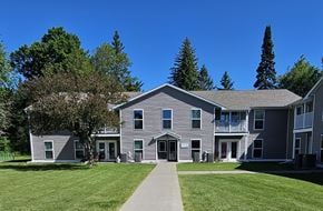Iron River apartment for rent - A grey building with a walkway in front of it.
