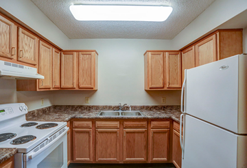 Dunkirk apartment for rent - a kitchen with white appliances and wooden cabinets