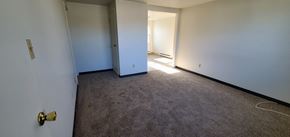 Leroy, Genesee County apartment for rent - a room with a carpeted floor and white walls and a door to a hallway