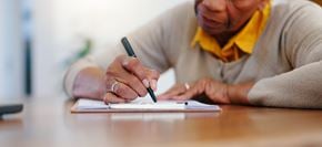 Delmar apartment for rent - A person is writing in a notebook with a pen.