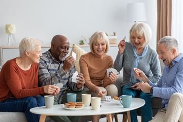 Mercer apartment for rent - A group of four people are sitting around a table playing a card game.