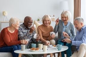 Delmar apartment for rent - A group of four people are sitting around a table playing a card game.
