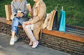 Mercer apartment for rent - Two people sitting on a bench with shopping bags and umbrellas.