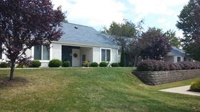 Bethesda apartment for rent - a white house with a lawn and a brick retaining wall