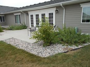 Plainwell apartment for rent - a patio with plants and chairs in front of a house