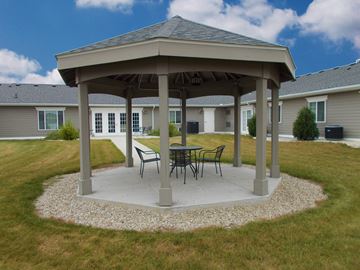 Plainwell apartment for rent - a gazebo with a table and chairs on a concrete patio