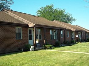 Galion apartment for rent - a brick house with a dog in the yard
