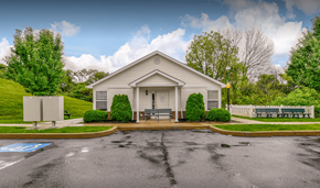 Barnesville apartment for rent - a parking lot in front of a white house with a bench