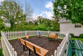 Barnesville apartment for rent - a fenced in backyard with a garden and benches