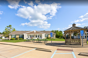 Greenville apartment for rent - a gazebo and picnic tables in a park in front of a house