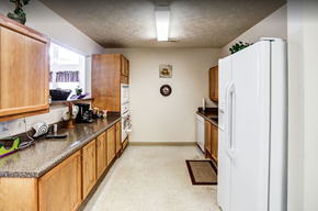 Greenville apartment for rent - a kitchen with wooden cabinets and a white refrigerator