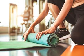 Queenstown townhouse for rent - a woman rolling up a yoga mat in a gym