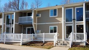 Munising apartment for rent - a tan house with a white fence in front of it