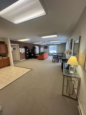 Parsons apartment for rent - A well-lit office space with a desk, chairs, and a lamp.