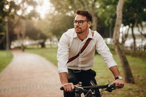 Sebring apartment for rent - A man in a white shirt and suspenders is riding a bicycle on a path.