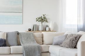Monticello apartment for rent - A white couch with grey pillows and a grey blanket.