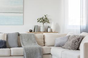 Wauchula apartment for rent - A white couch with grey pillows and a grey blanket.