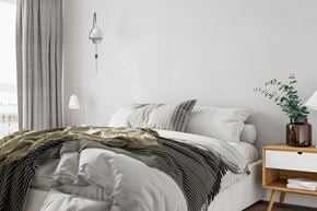 Sistersville apartment for rent - A bed with a white comforter and a green striped blanket.