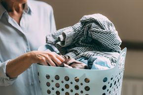Mercer apartment for rent - A person is holding a laundry basket full of clothes.