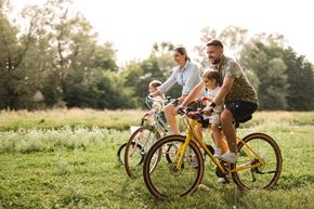 Wauchula apartment for rent - A family of three is riding a bicycle together in a field.