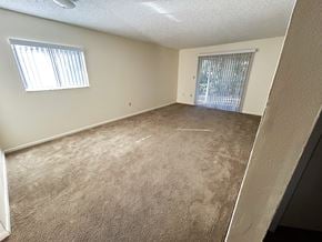 Eustis apartment for rent - A room with a carpeted floor and a window with blinds.