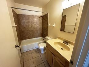 Eustis apartment for rent - A bathroom with a white tub, sink, and toilet.