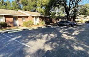 Eustis apartment for rent - A black car is parked in a parking lot in front of a brick building.