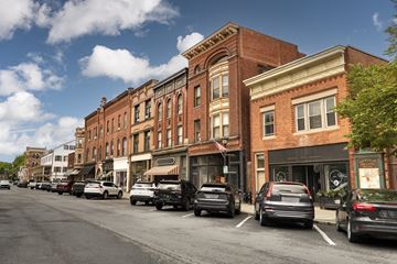 Ballston Spa apartment for rent - Cars parked on the side of a street in front of a row of buildings.