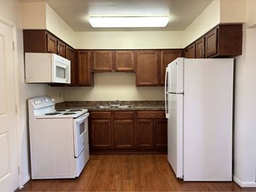 Salisbury apartment for rent - A kitchen with white appliances and brown cabinets.