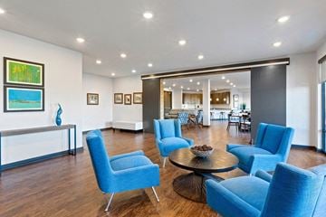 Ashburn apartment for rent - A living room with blue chairs and a table.
