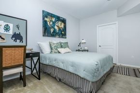 Oxnard apartment for rent - A bedroom with a bed, a chair, and a painting on the wall.