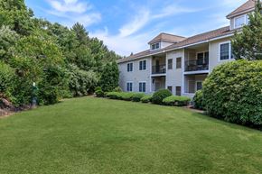 Manchester apartment for rent - A large grassy area in front of a building with trees on the left.
