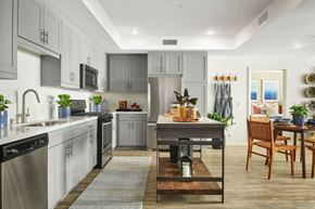 Riverside apartment for rent - A modern kitchen with a dining table and chairs.